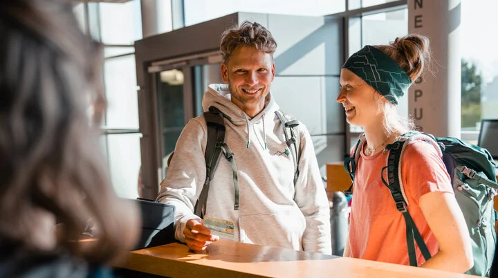 Zwei Personen stehen im ANmeldebereich einer Boulderhalle | © DAV/Marisa Koch