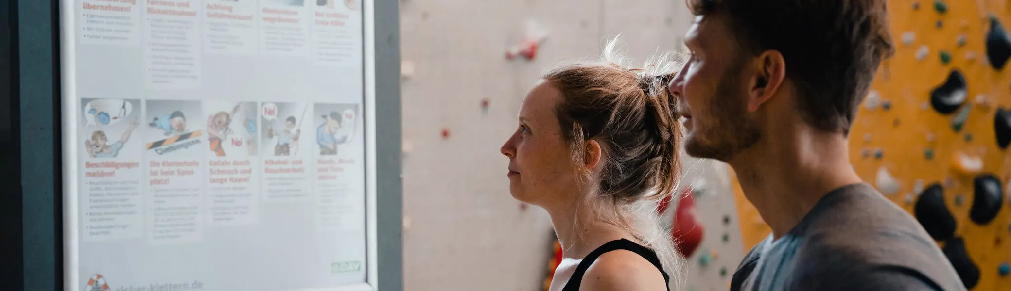 Zwei Personen checken den Trainingsplan, der an einer Wand hängt | © DAV/Marisa Koch