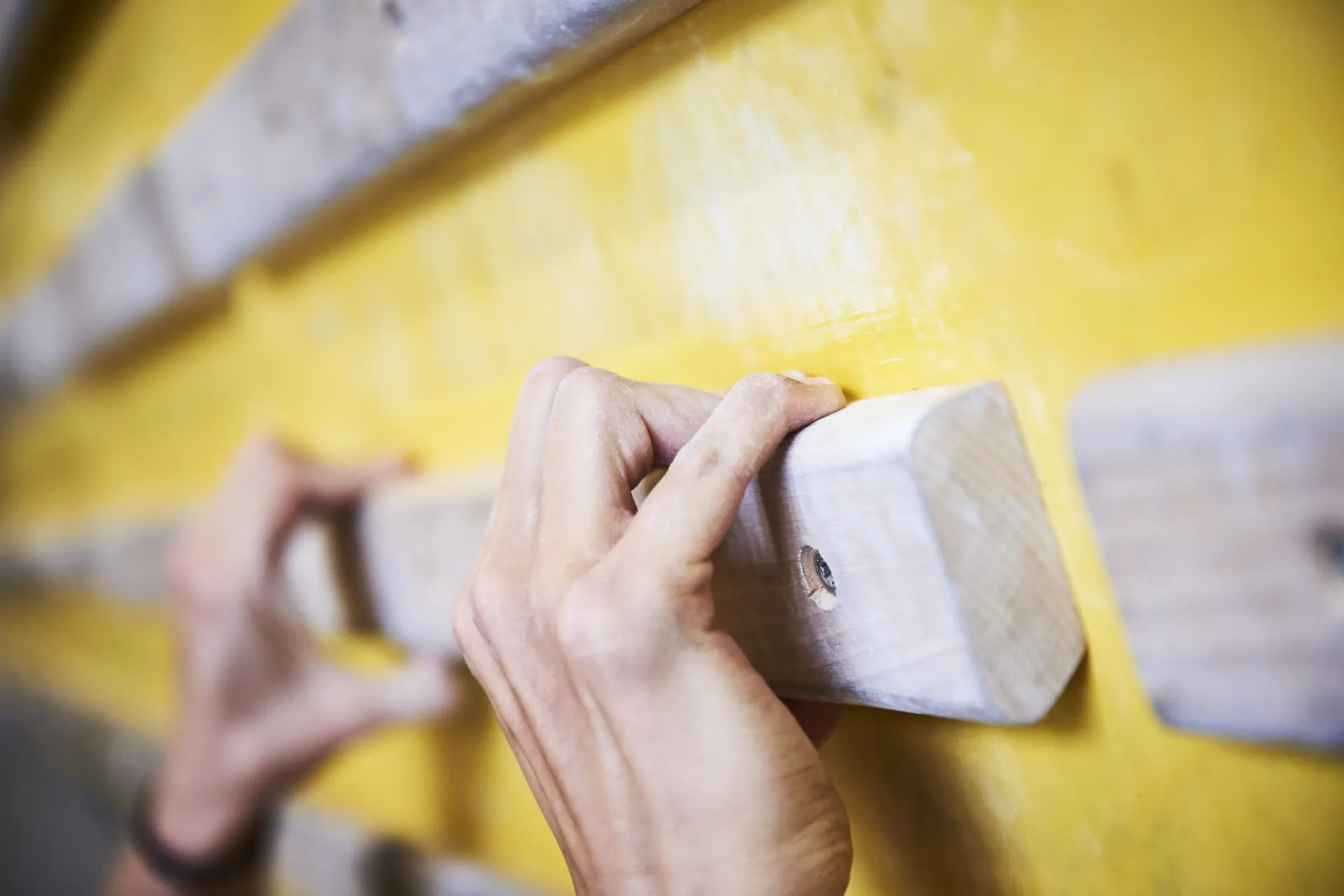 Hände greifen nach Holzelementen an einer Kletterwand | © DAV/Frank Kretschmann